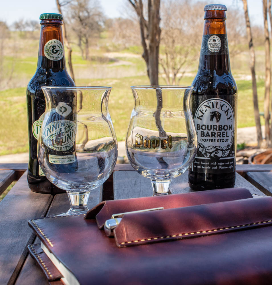 Innis & Gunn and KBS bottles on table with two empty glasses.
