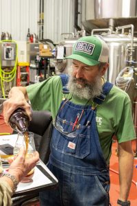 John Maier pouring a sample of a pilot beer he's working on.
