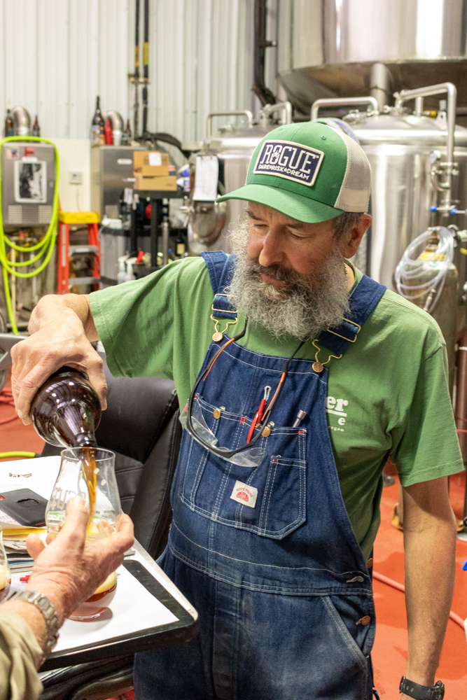 John Maier pouring a sample of a pilot beer he's working on.