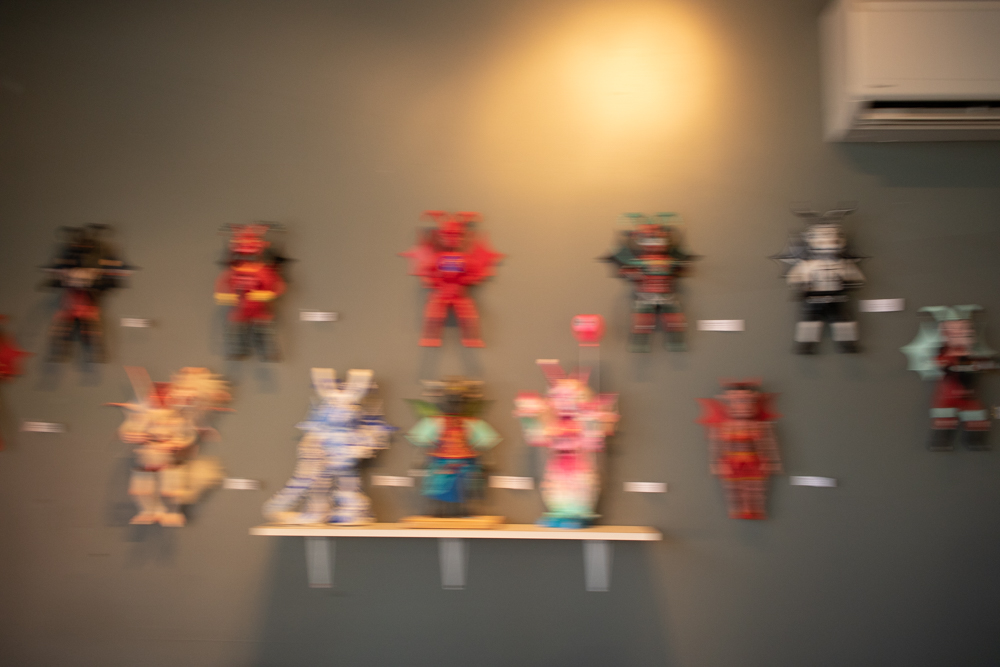 Blurry photo of winged creature dolls on the wall at Gigantic Brewing.