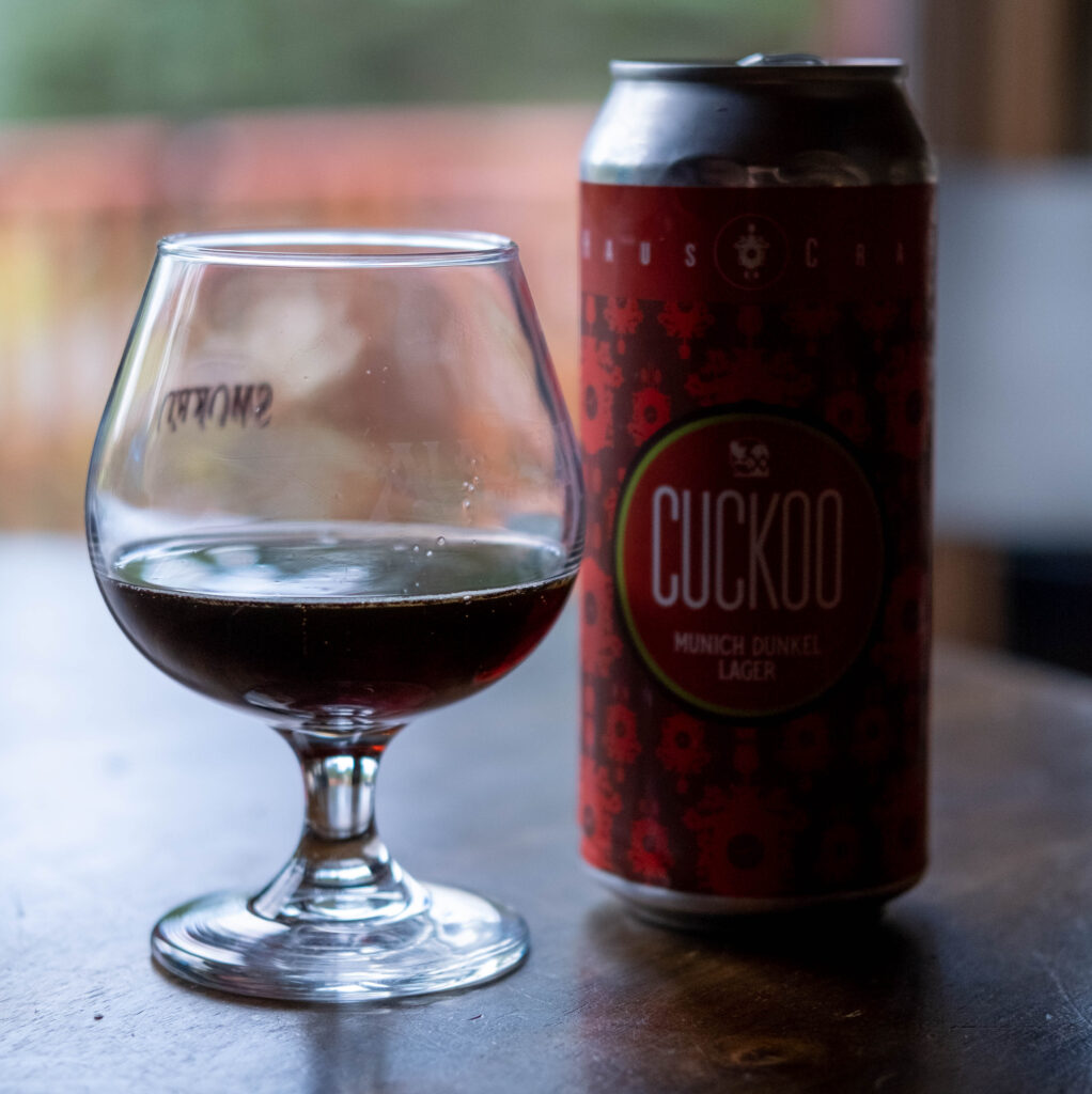 Cuckoo beer in a glass, with cuckoo munich dunkel lager can on the background