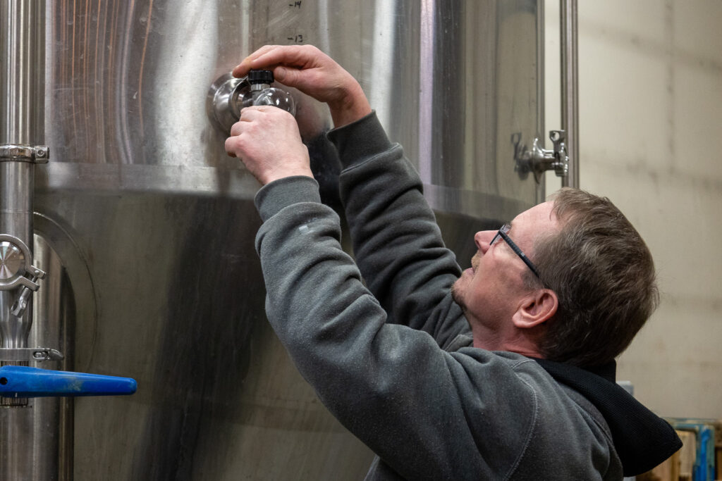 Ted Rosenzweig pulling a sample of base wort from the tank.