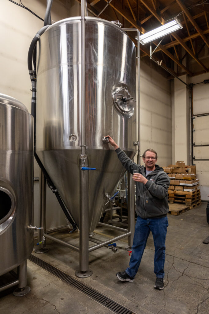 Ted Rosenzweig standing next to the tank full of his base sour wort, which is used for all his sour beers.