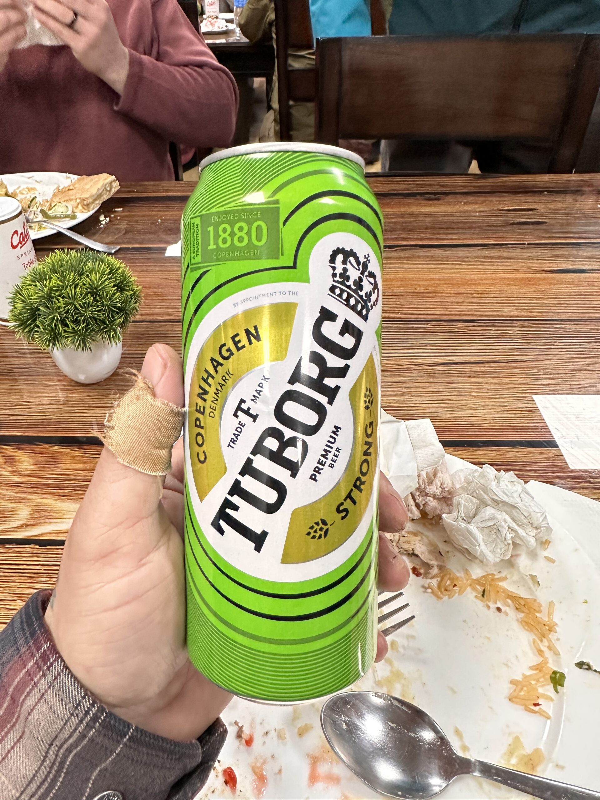 Can of Tuborg held in the hand.