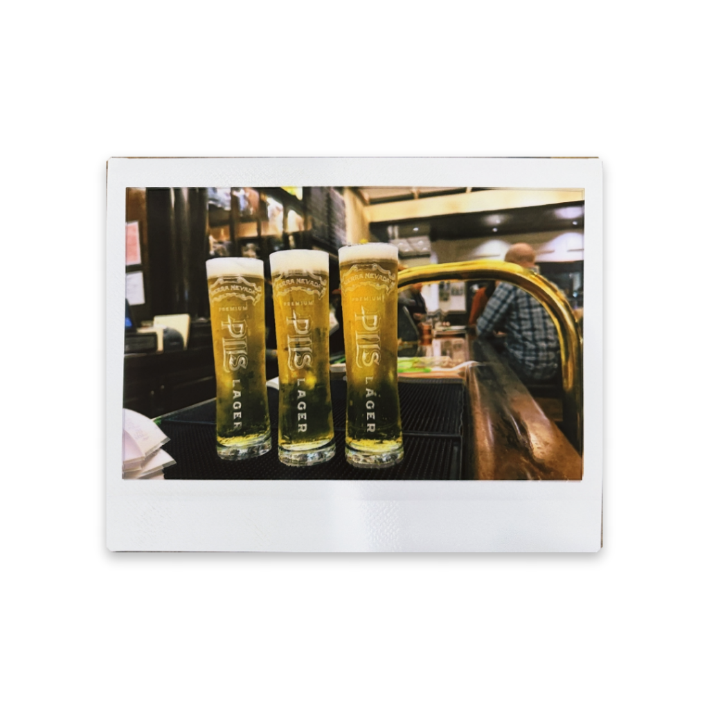 Instax Wide photo of three 8 oz. Pilsner glasses sitting on a bar